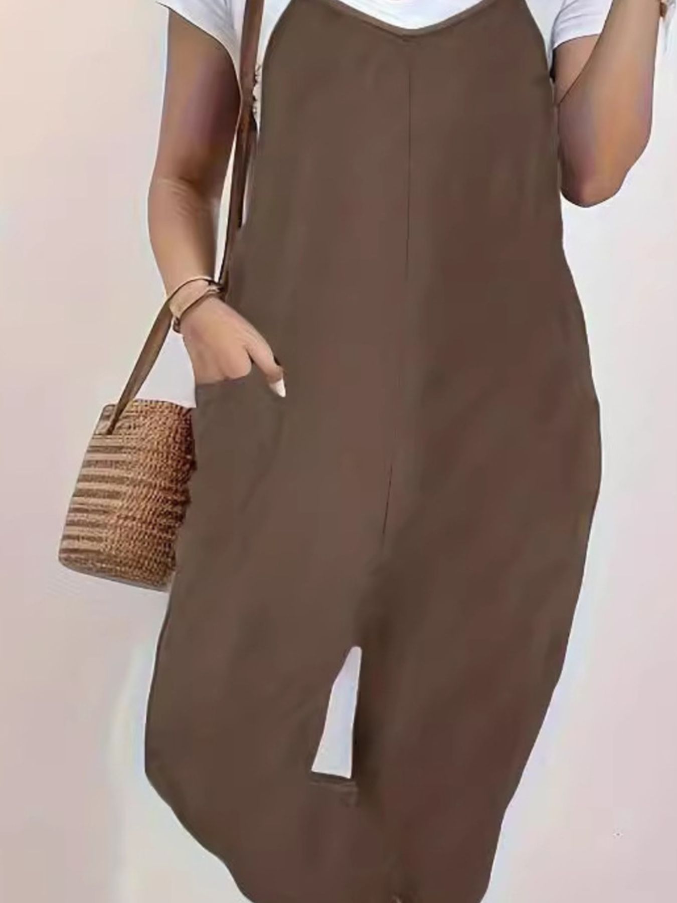 Casual loose fit spaghetti strap jumpsuit with pockets, styled in a relaxed silhouette, by Trendsi.
