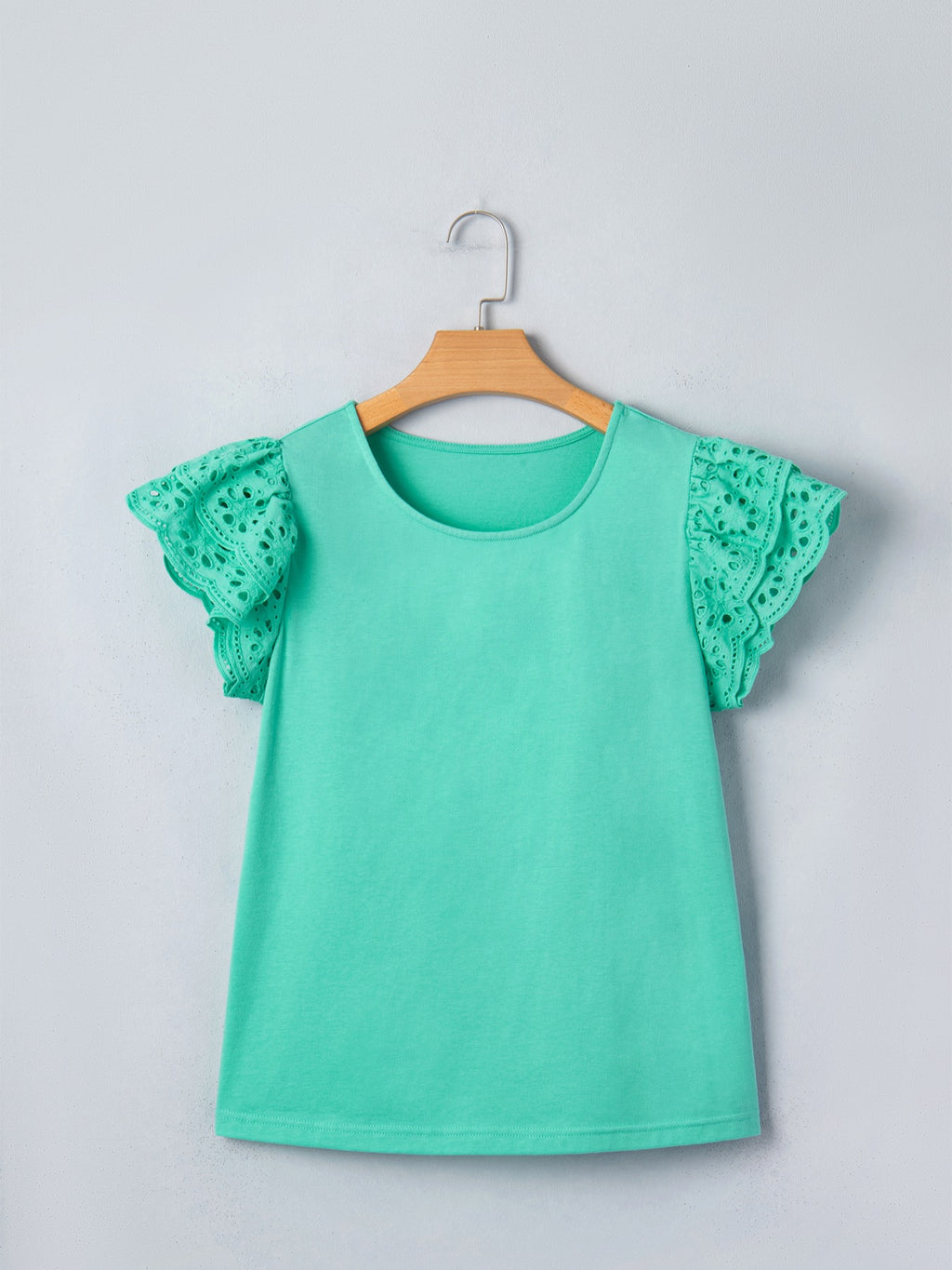 Ruffled eyelet lace cap sleeve top with cutout detail, featuring feminine design and intricate lace fabric, from Trendsi tops collection.