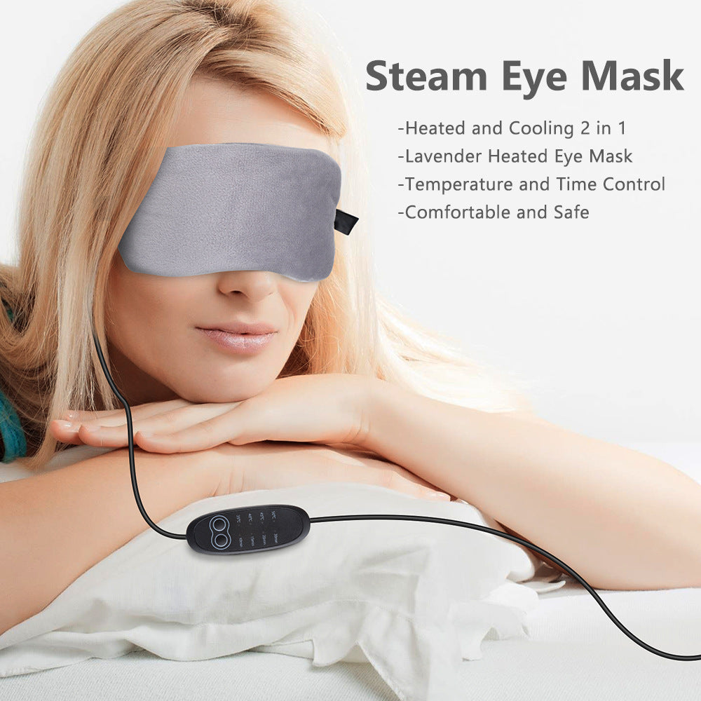 Gray plush steam eye mask with corded controller worn by a woman with blonde hair.