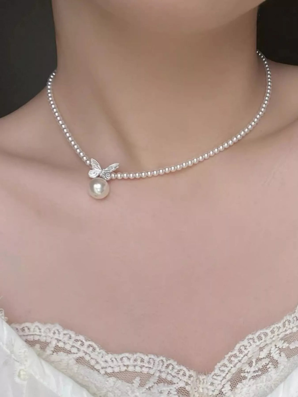Pearl butterfly pendant necklace from Plush Fashion Hub featuring a delicate pearl and butterfly charm on a silver chain.