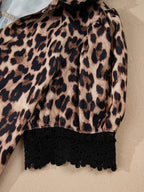 Leopard print short sleeve blouse with lace trim and button front by Plush Fashion Hub, shown on a hanger.