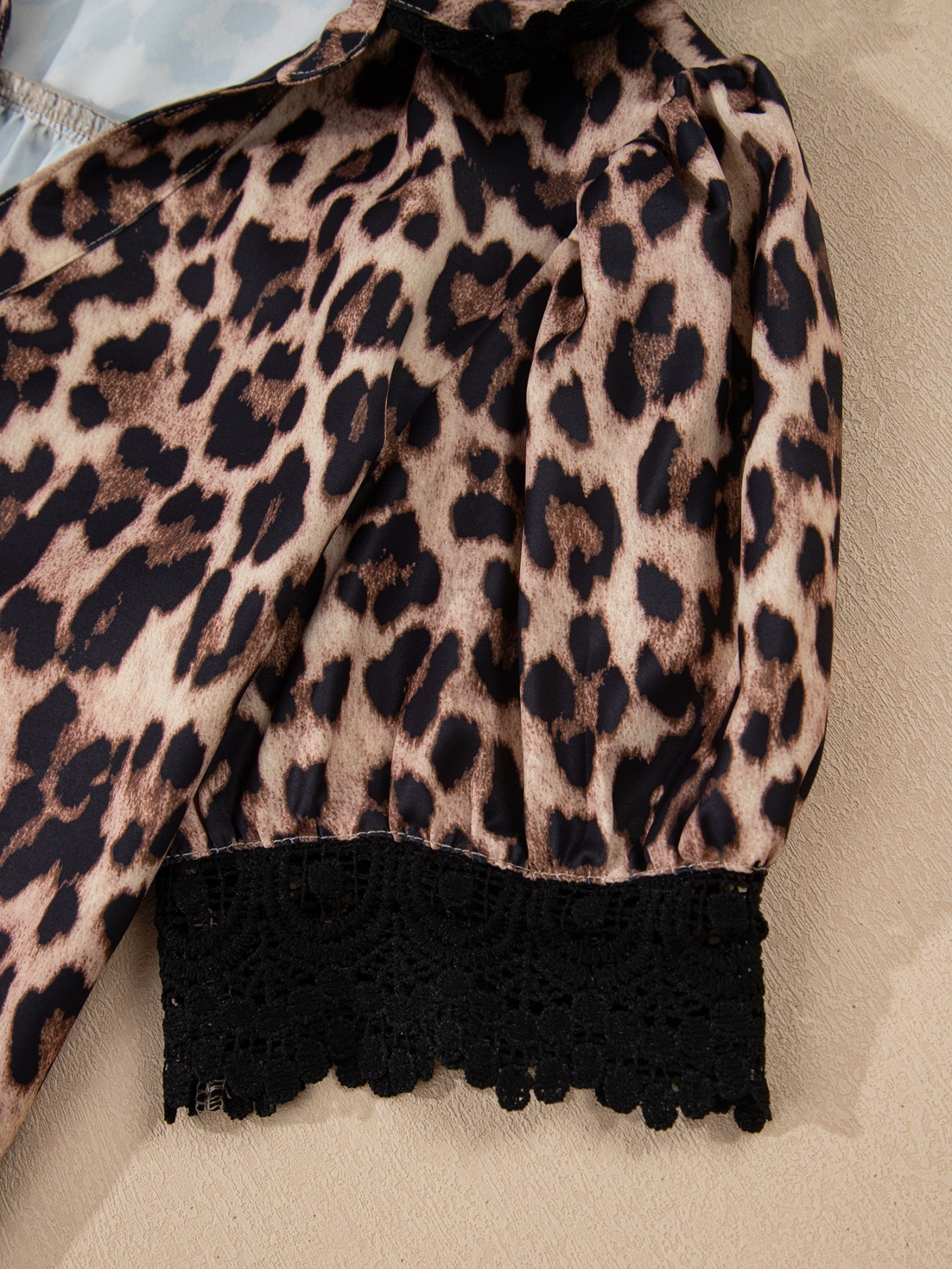 Leopard print short sleeve blouse with lace trim and button front by Plush Fashion Hub, shown on a hanger.