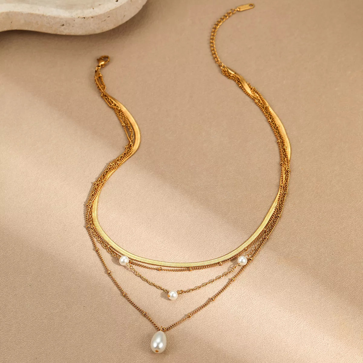 18K gold-plated four-layer pearl necklace with white pearls and gold accents, showcasing a luxurious and elegant jewelry design