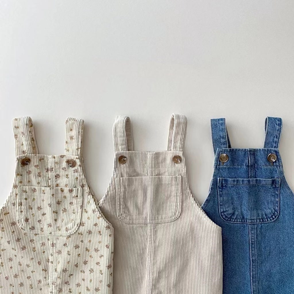 Three child's overalls: floral corduroy, striped corduroy, and blue denim, each with chest pockets and brown buttons.