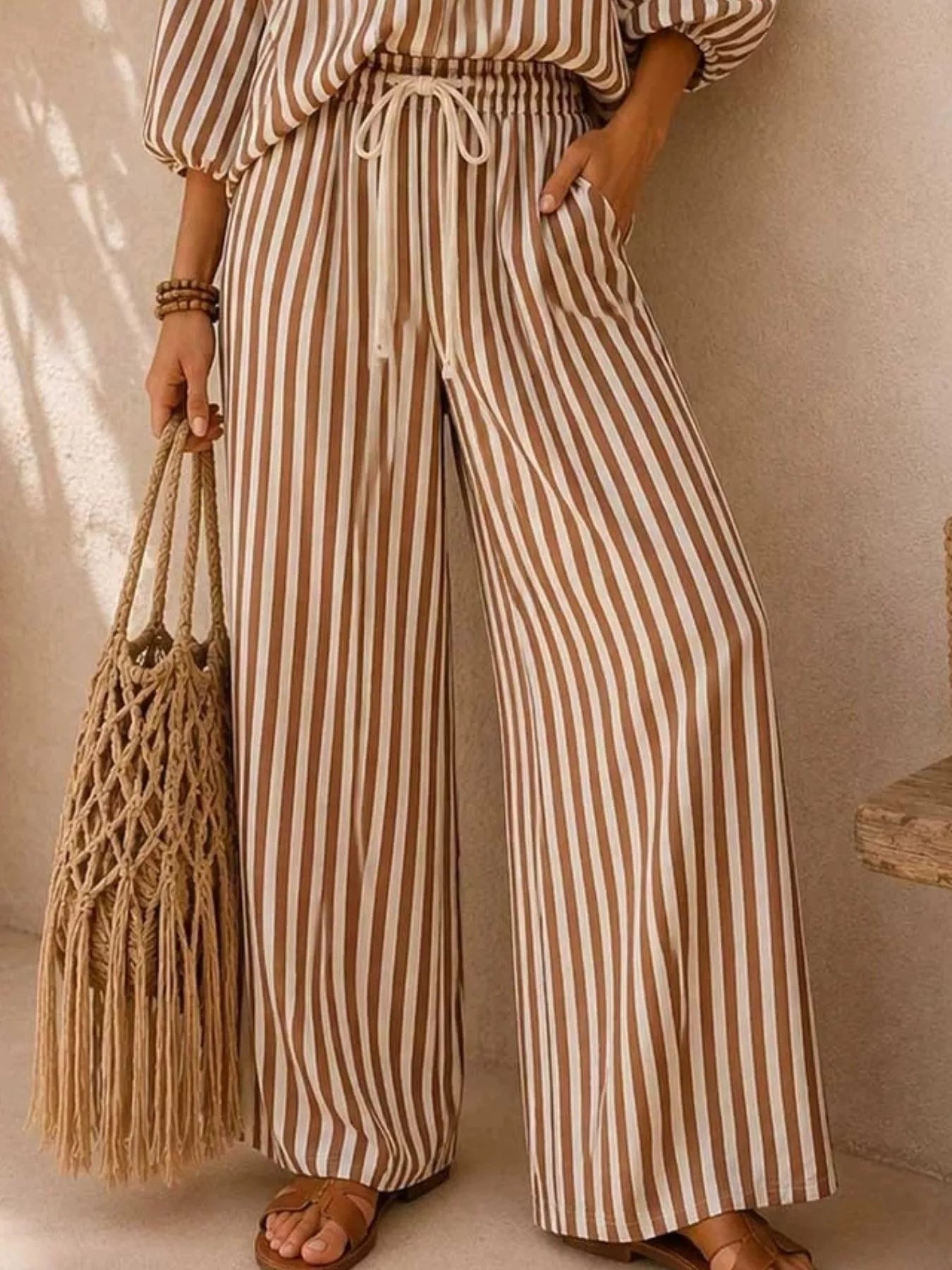 Plus size striped puff sleeve shirt and wide-leg drawstring pants set by Trendsi, featuring comfortable fabric and stylish design.