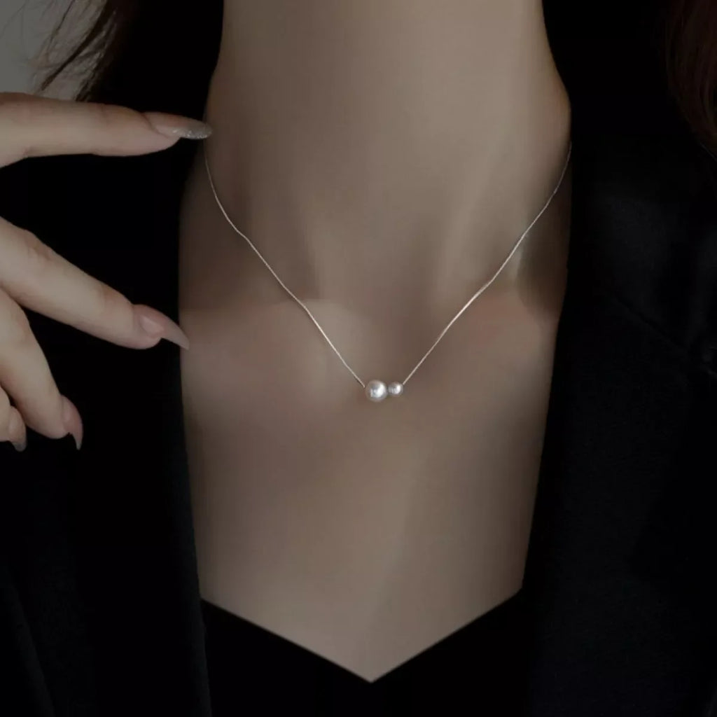 Sterling silver pearl necklace with lustrous white pearls and delicate chain, elegant jewelry accessory from Shopimist.