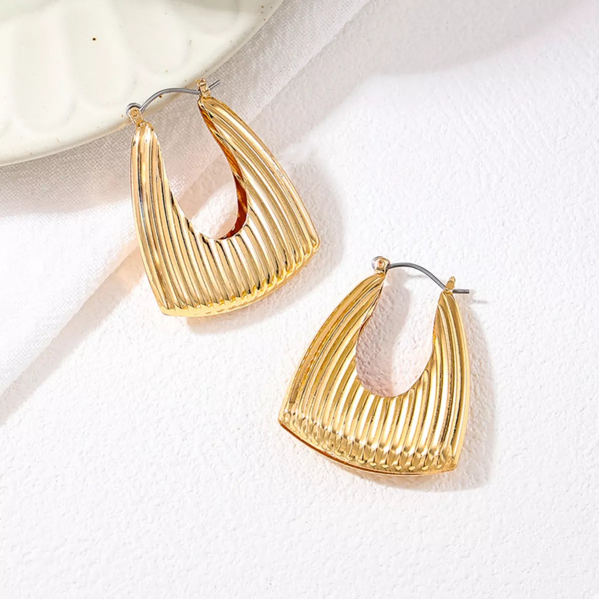 Gold-plated alloy triangular hoop earrings with ribbed design, stylish jewelry by Plush Fashion Hub.