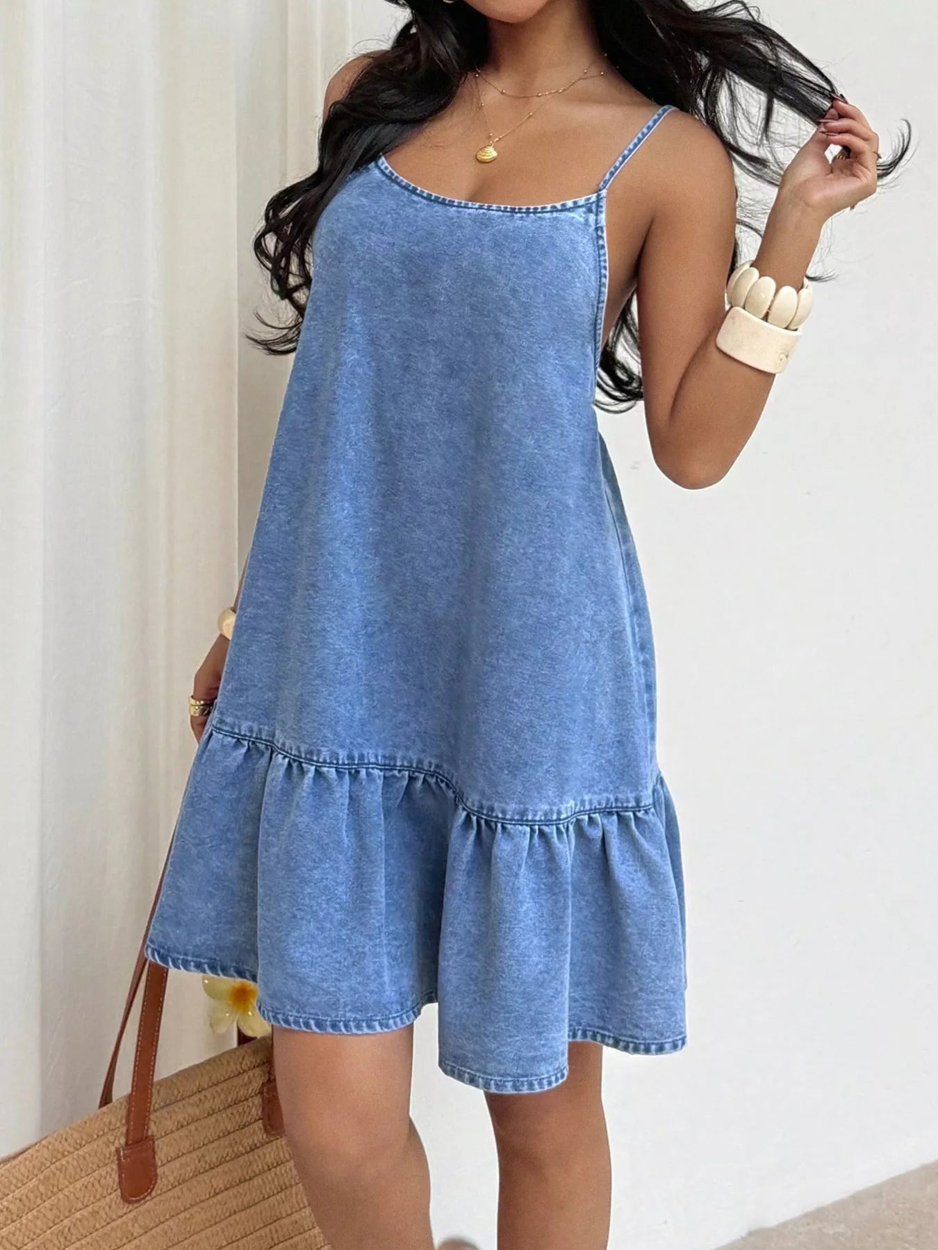 Casual denim spaghetti strap dress with ruffle hem by Plush Fashion Hub, showing a stylish sleeveless denim dress with ruffle details.