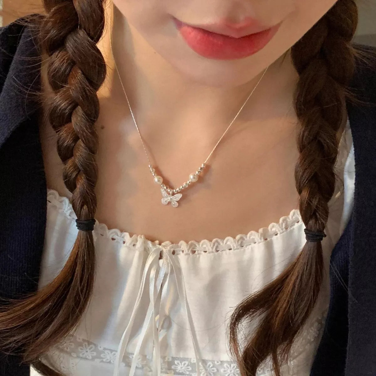 Elegant butterfly pearl pendant necklace from Plush Fashion Hub featuring a delicate pearl and butterfly charm on a silver chain.