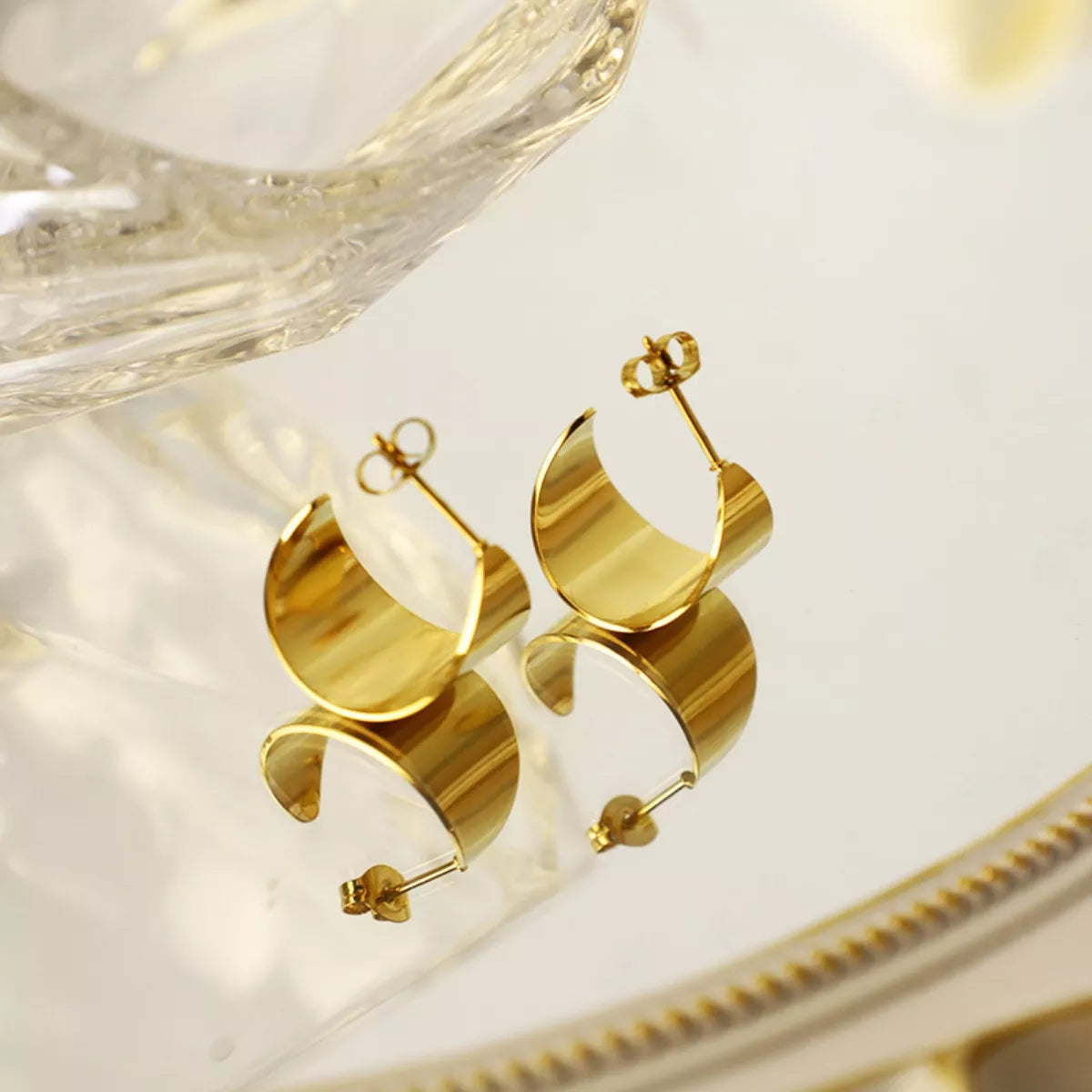 18K gold-plated stud earrings with a simple, elegant design, displayed on a white background, showcasing their shiny finish and craftsmanship.