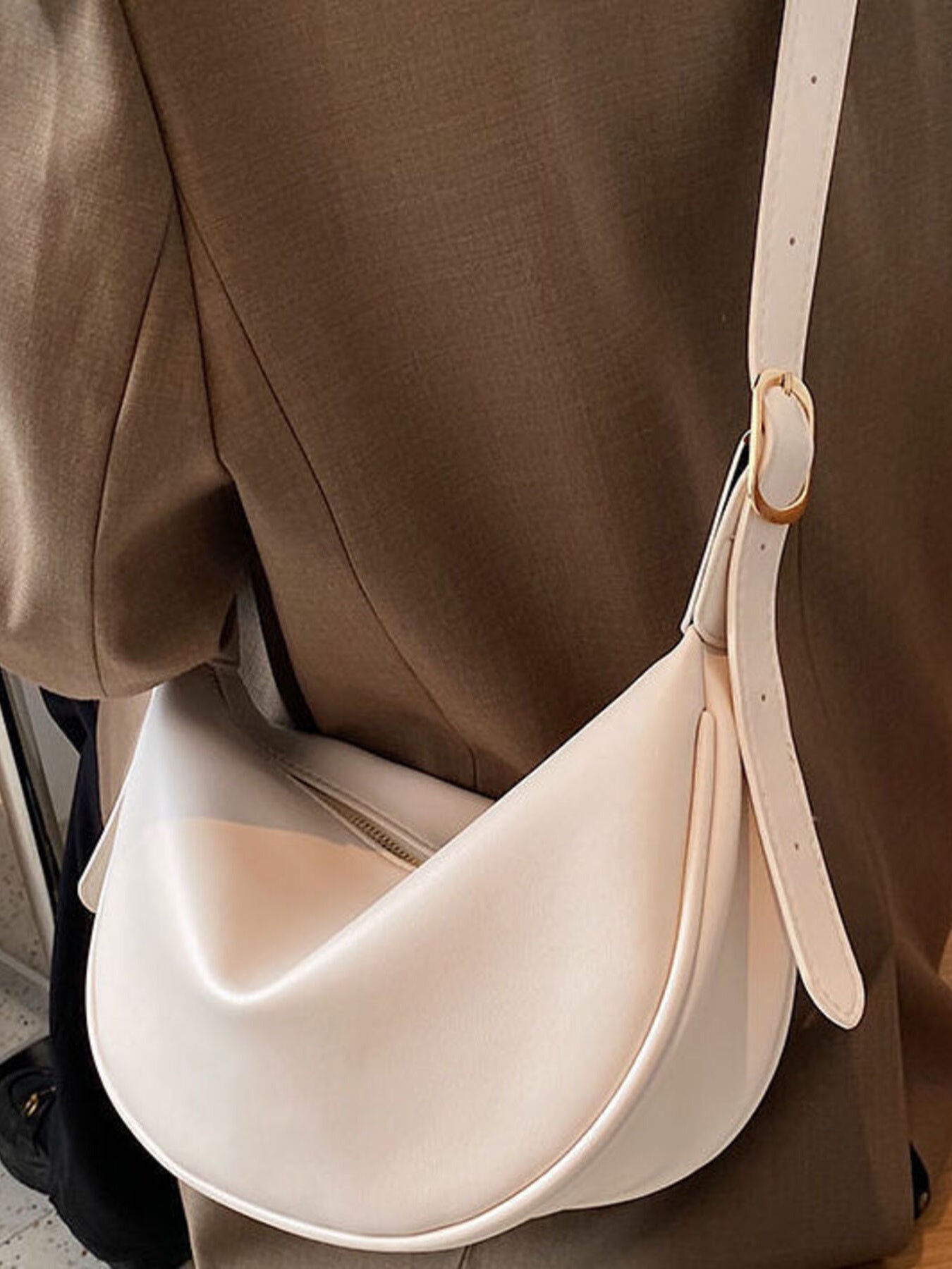 Minimalist crescent-shaped crossbody bag in smooth PU leather, trendy shoulder purse for casual and chic outfits.