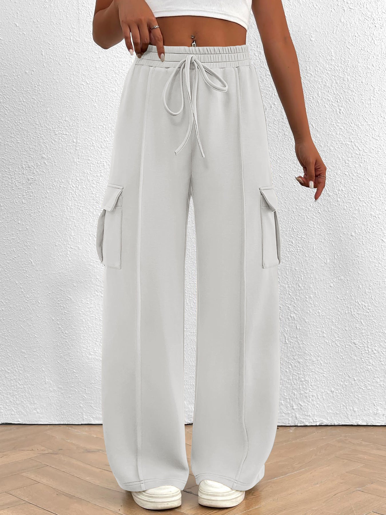 Lightweight women's high-waisted casual cargo pants with drawstring waistband, featuring utility-style pockets in neutral tones.