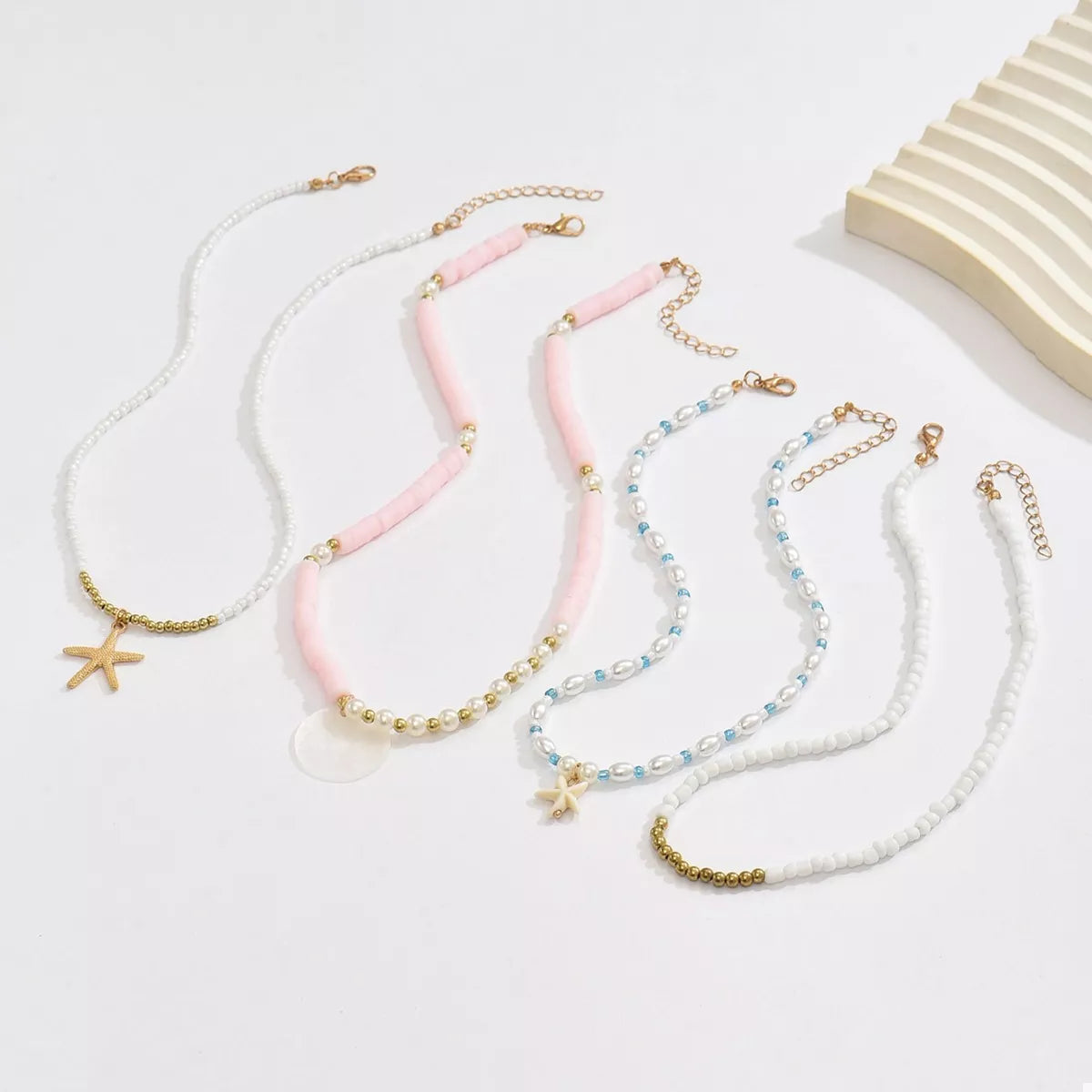 Beaded starfish charm necklace with four strands from Plush Fashion Hub, featuring colorful beads and coastal-inspired design.