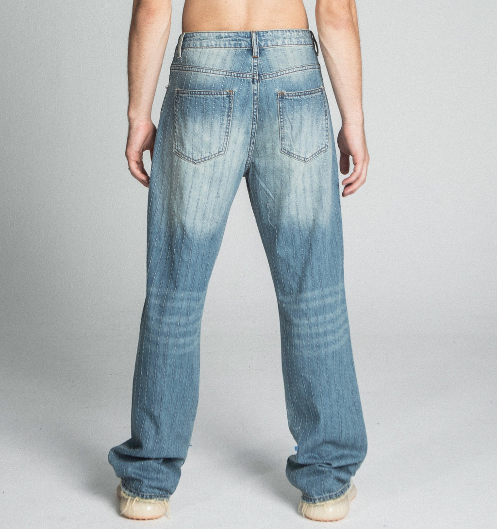 Ripped blue loose jeans by Armor Jeans, featuring distressed details and a relaxed fit, shown in the product image.