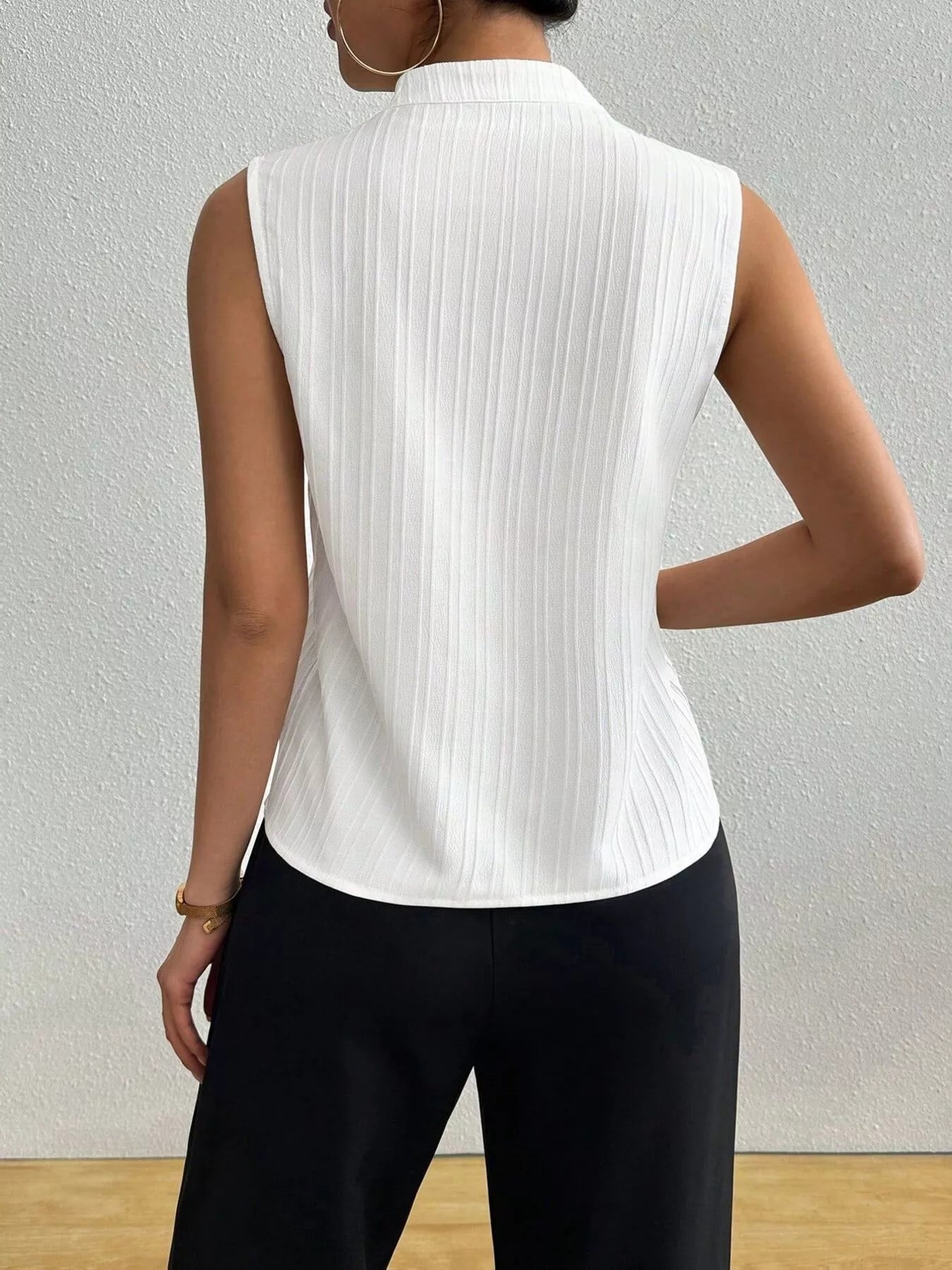 Women's textured notched neck sleeveless tank top from Trendsi, versatile basic shell, showcasing the stylish notch neckline and sleeveless design.