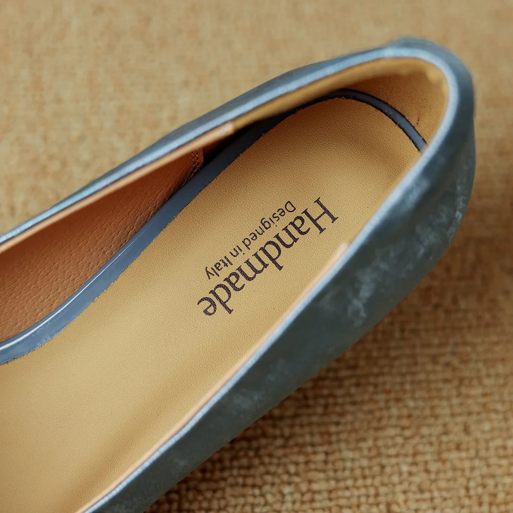 Close-up of a blue genuine leather stiletto heel interior with a tan insole marked "Handmade, Designed in Italy."