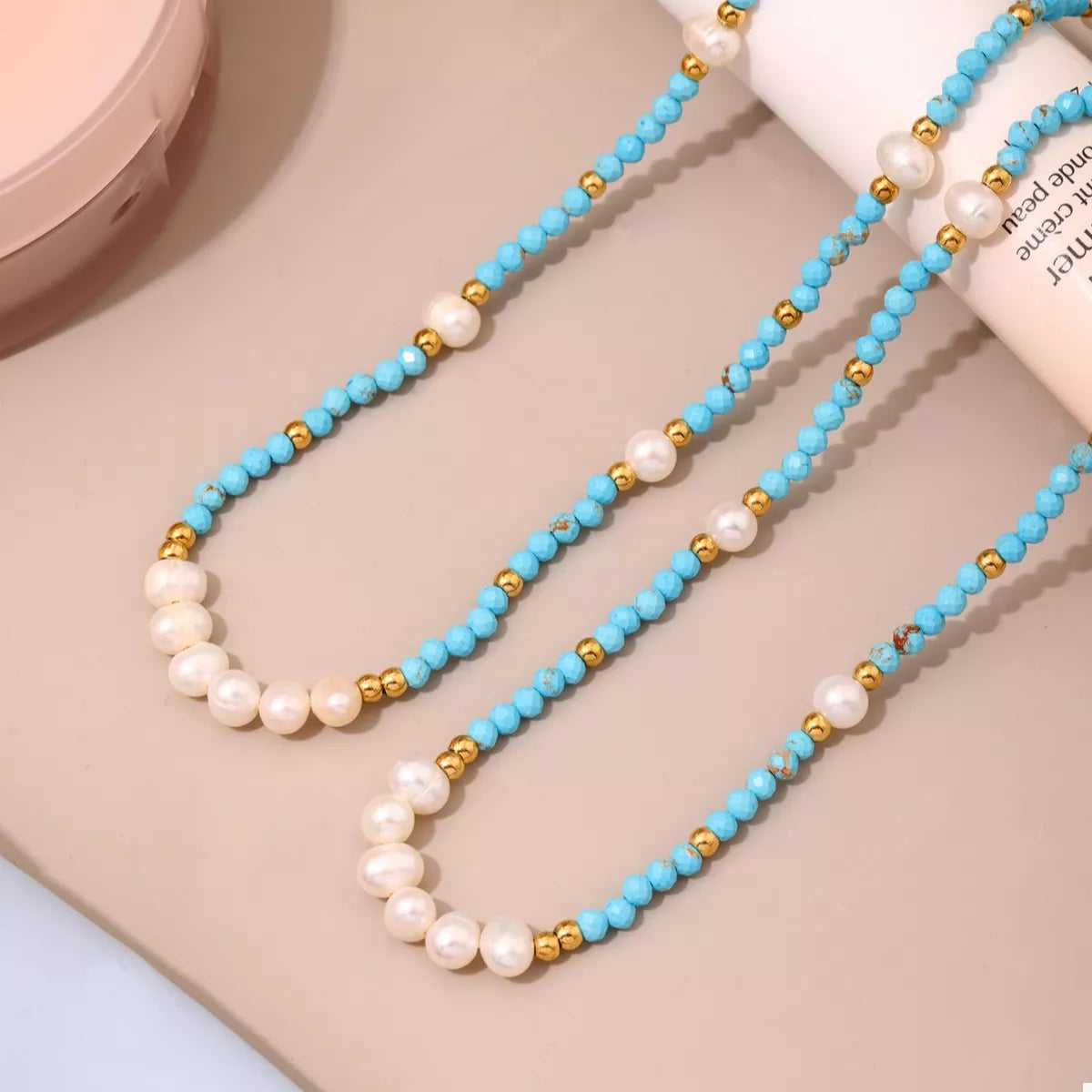 Turquoise pearl beaded necklace from Shopimist featuring round beads and a delicate clasp on a neutral background.