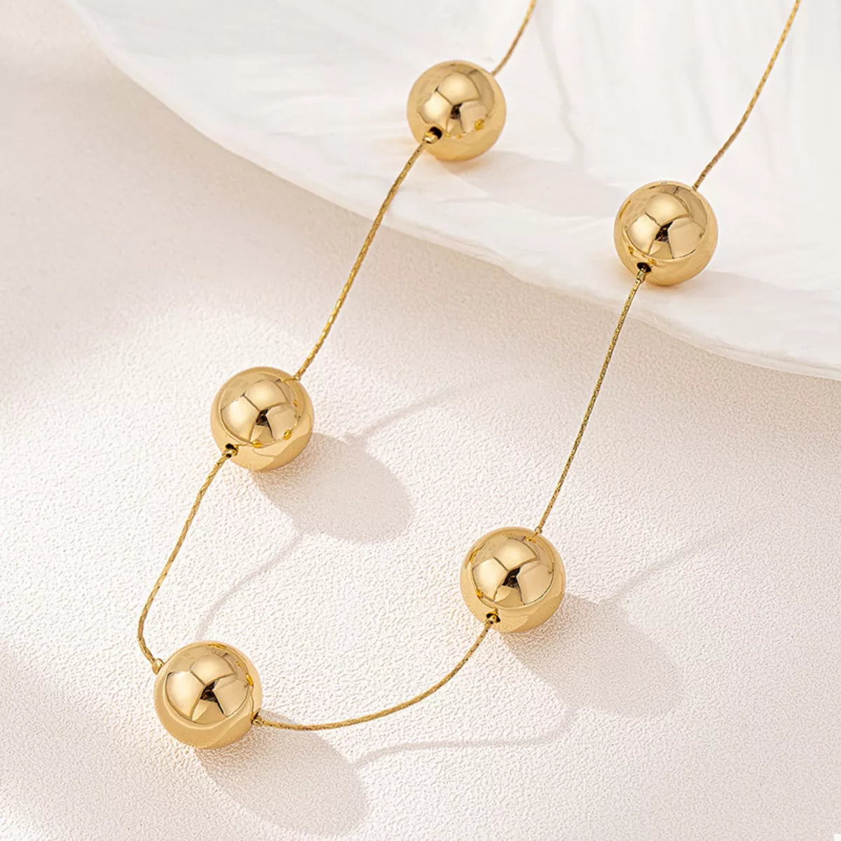 Golden sphere statement necklace from Plush Fashion Hub featuring bold, spherical pendant on a sleek chain.