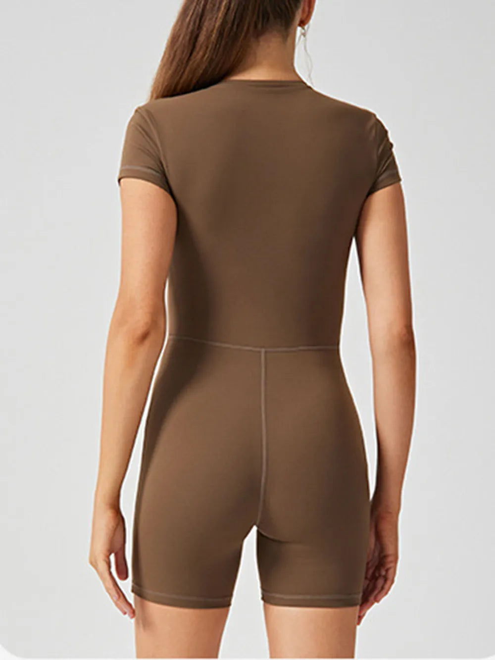 Trendsi half zip short sleeve active romper in breathable fabric, shown on a hanger with a sleek, sporty design.