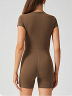 Trendsi half zip short sleeve active romper in breathable fabric, shown on a hanger with a sleek, sporty design.