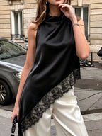 Polka dot lace trim sleeveless blouse with asymmetrical hem, stylish shirt from Trendsi featuring a feminine design and lightweight fabric.