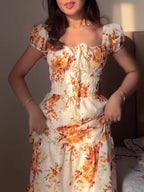 Women's floral print short sleeve ruched maxi dress by Trendsi, featuring a flowing design and vibrant floral pattern.