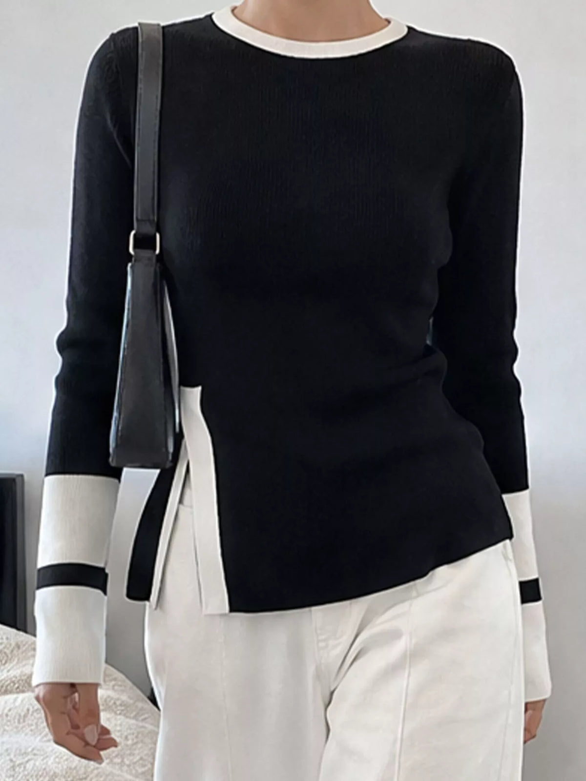 Black side slit contrast trim sweater from Trendsi, featuring a cozy knit fabric, stylish design, and subtle color contrast details.