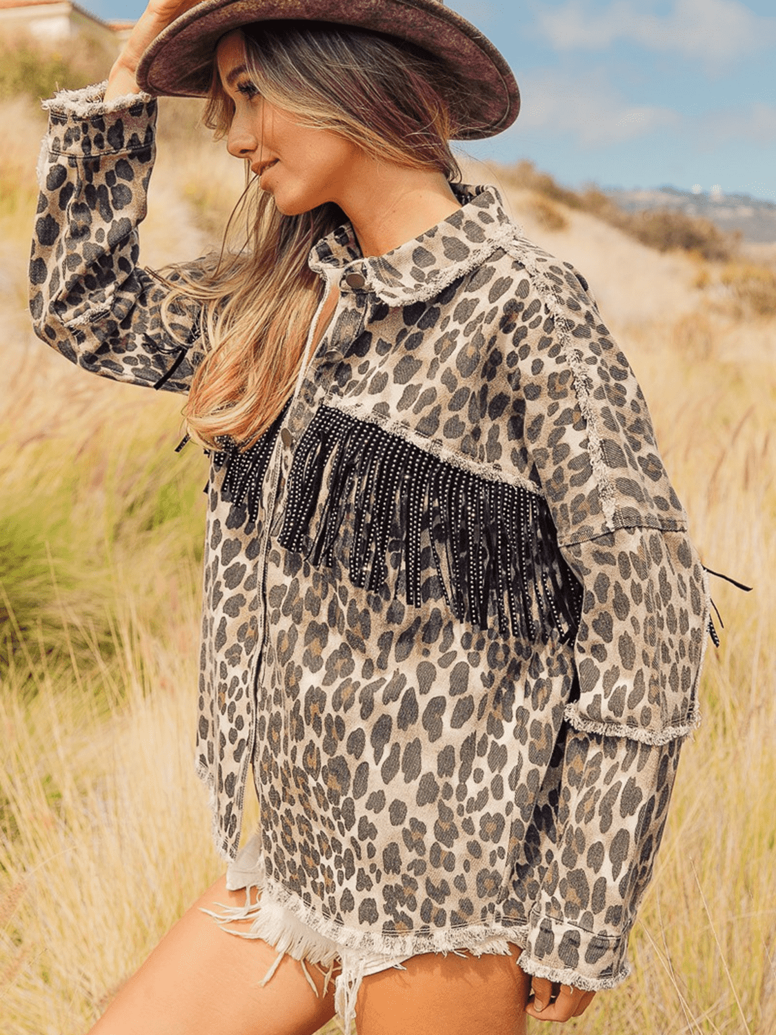 VYSN leopard fringe detail denim jacket with collared neckline and stylish design, featuring leopard print accents and fringe embellishments.