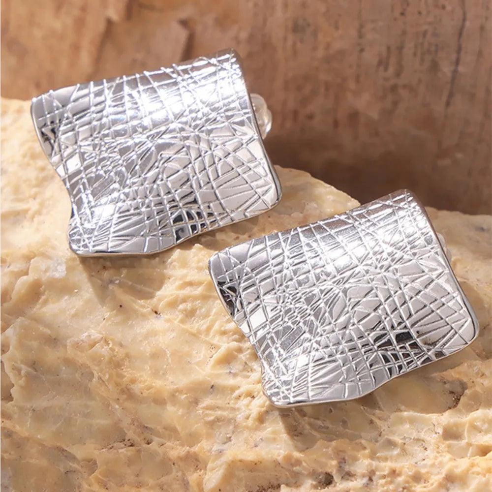 Textured titanium steel stud earrings with a sleek, modern design, showcasing a shiny, durable finish.