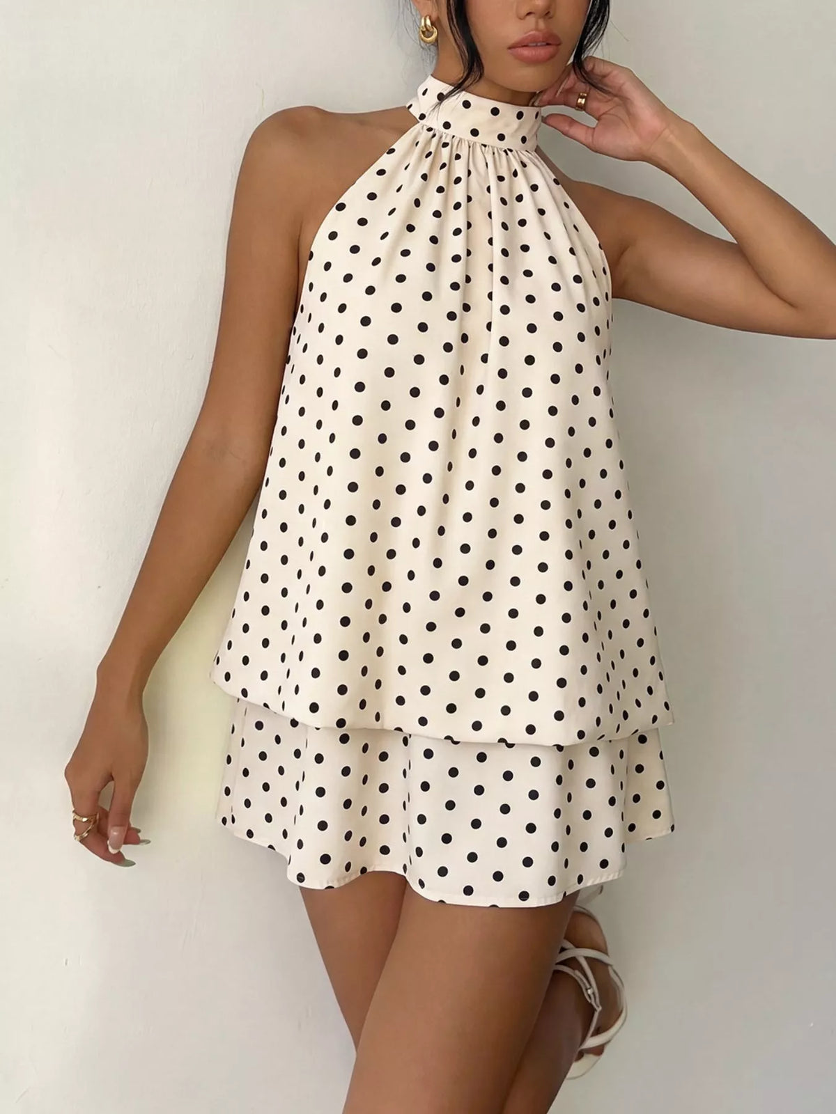 Polka dot halter neck mini dress by Plush Fashion Hub featuring a fitted bodice and flared skirt on a white background.