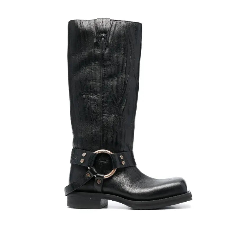 Black leather knee-high boot with a square toe, low heel, and a buckled harness strap featuring a round metal ring.