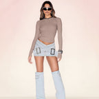 Women's light blue denim mini skirt with bodycon fit and cross-over buckle design by FitiqueFit, shown on a model.