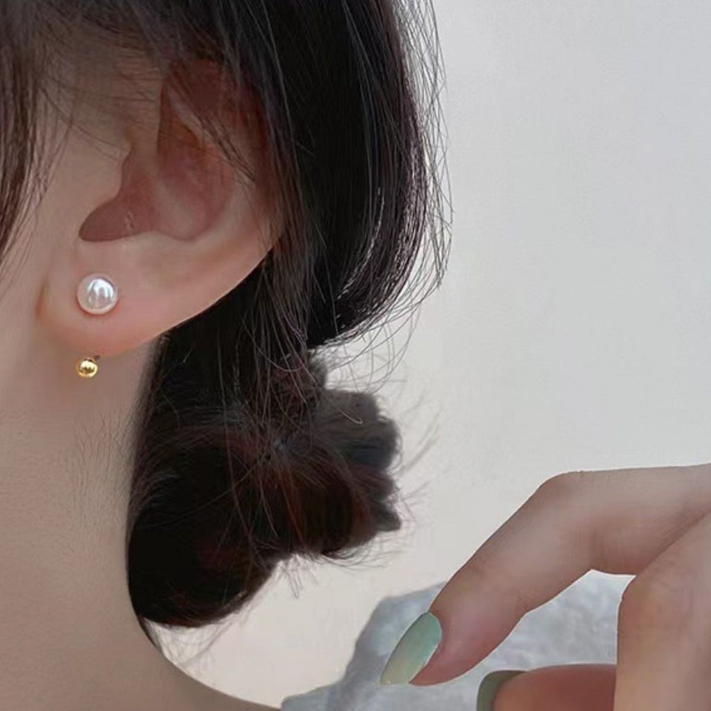 Sterling silver pearl stud earrings with smooth, round pearls and silver posts, elegant jewelry accessory.