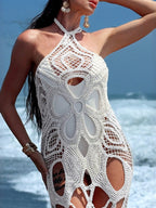 Black cutout halter neck cover-up dress by Trendsi featuring a stylish open back and flowy silhouette.