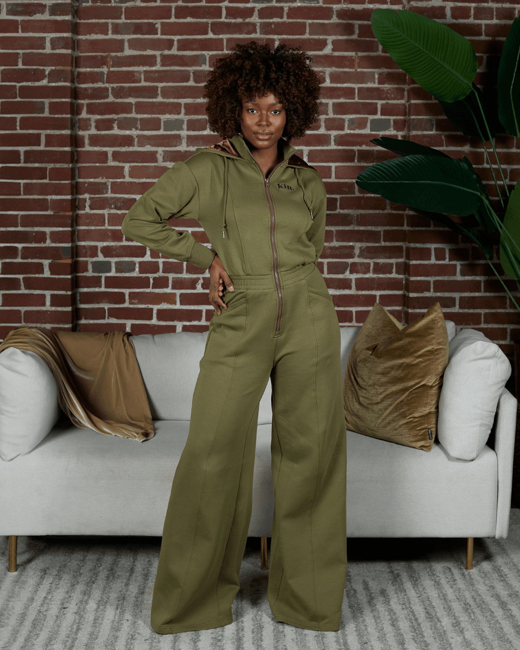 Green satin-lined jumpsuit by Plush Fashion Hub, featuring a sleek design and smooth fabric, shown on a model.