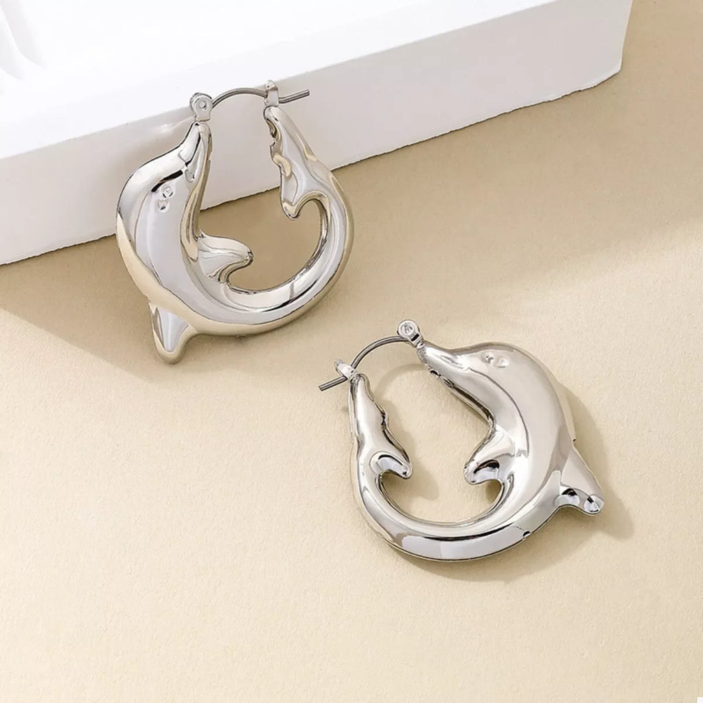 18K gold-plated dolphin hoop earrings with detailed dolphin design, shiny finish, and secure clasp on a plain background.