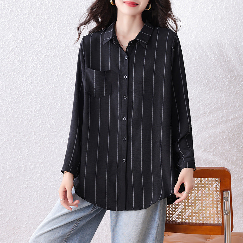 Black long-sleeve button-down shirt with white vertical stripes, collar, and chest pocket, worn with jeans.