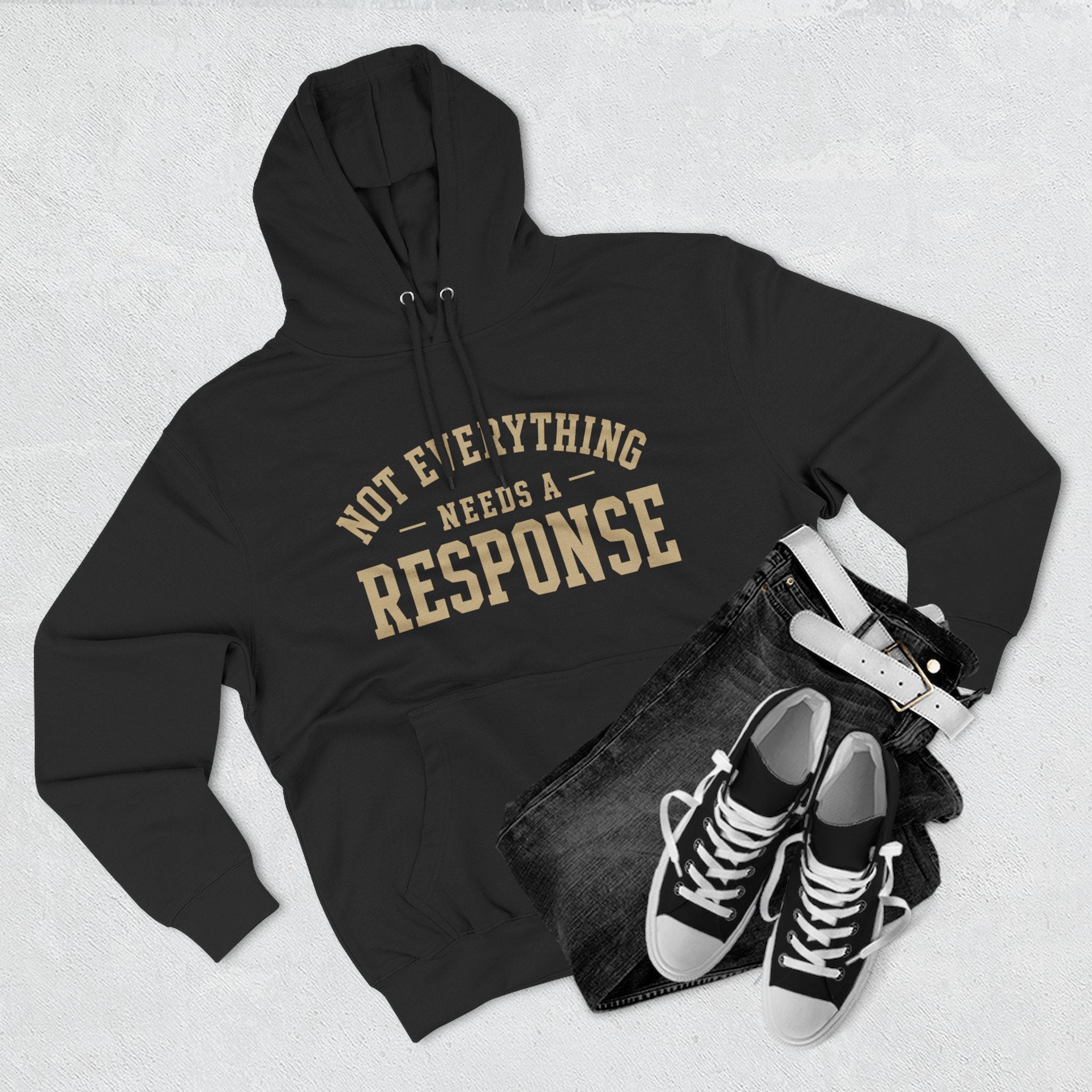 Black "Not Everything Needs a Response" hoodie by Wear Your Worship from the SEEN. Identity Line, featuring bold white text on the front.