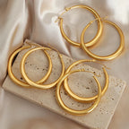 18K gold-plated hoop earrings by Shopimist, medium-sized, shiny circular jewelry with smooth finish on a white background.