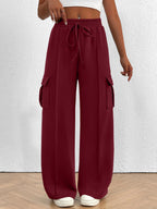 Women's high-waisted casual cargo pants with drawstring, lightweight utility style, in neutral fabric, shown on a model.