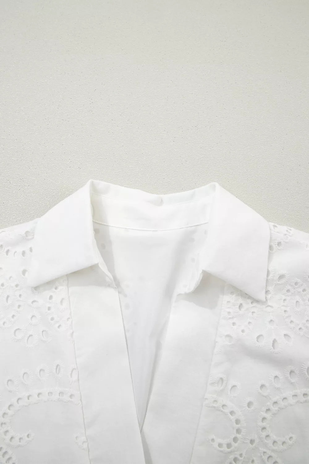 Solid color eyelet embroidered mini dress by Trendsi featuring a casual T-shirt style with eyelet details and embroidery.