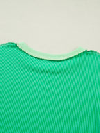Women's ribbed twist hem short sleeve T-shirt with contrast stitching, featuring a fitted style and subtle ribbed texture.