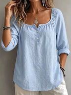 Long sleeve top with button details from Trendsi, featuring a fitted design and soft fabric in a neutral color.