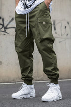 Men’s multi-pocket drawstring cargo pants in streetwear style by Plush Fashion Hub, featuring multiple utility pockets and a relaxed fit.