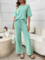 Women's casual two-piece lounge set with round neck top and drawstring pants from Trendsi, comfortable and stylish for relaxed wear.