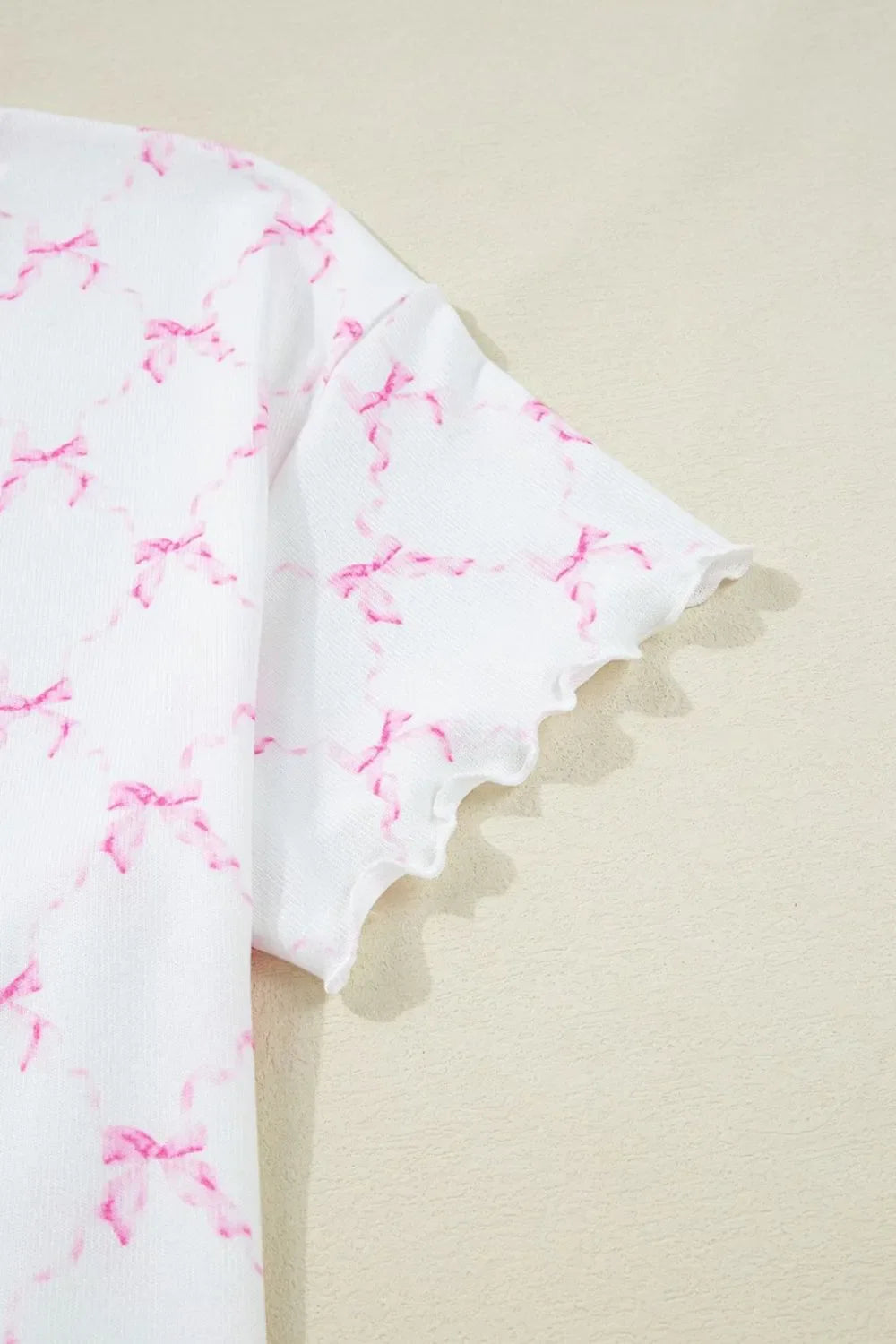 Simply Love bow print lettuce trim round neck top and shorts lounge set, featuring a comfortable, stylish matching sleepwear outfit.