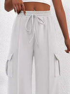 Lightweight women's high-waisted casual cargo pants with drawstring and utility pockets, displayed on a model.