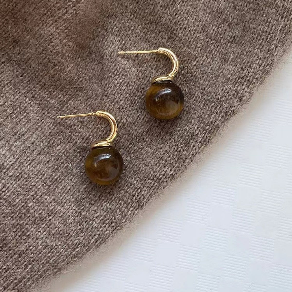 Tiger Eye ball drop earrings from Plush Fashion Hub featuring gold-tone hooks and polished tiger eye gemstone beads.