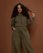 Green satin-lined jumpsuit by Plush Fashion Hub, featuring a stylish fit with long sleeves and a tapered leg silhouette.