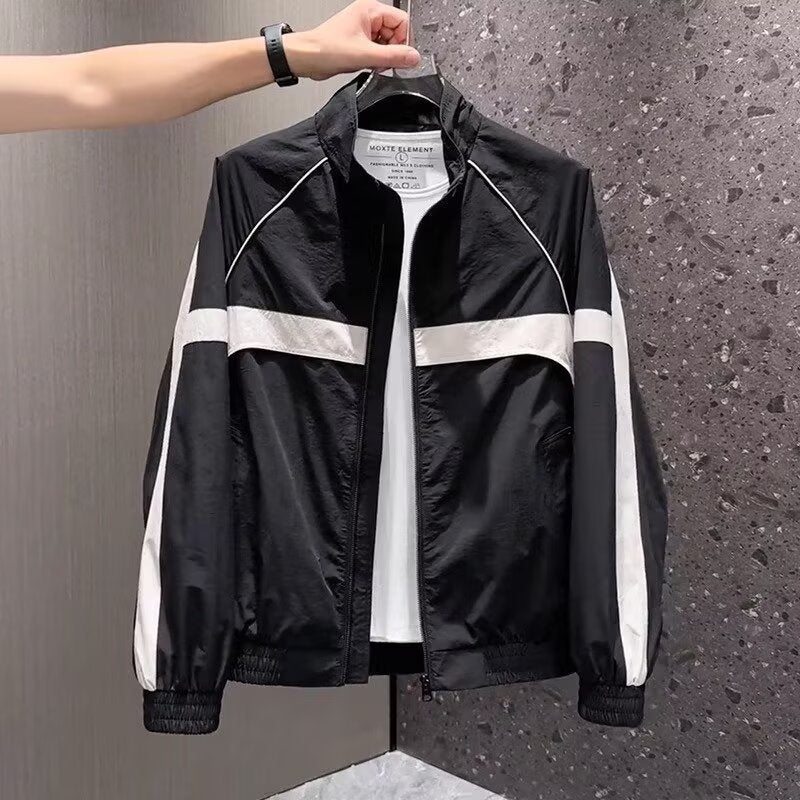 Black nylon track jacket with a white chest stripe, stand-up collar, and white sleeve stripes held up by a hand.